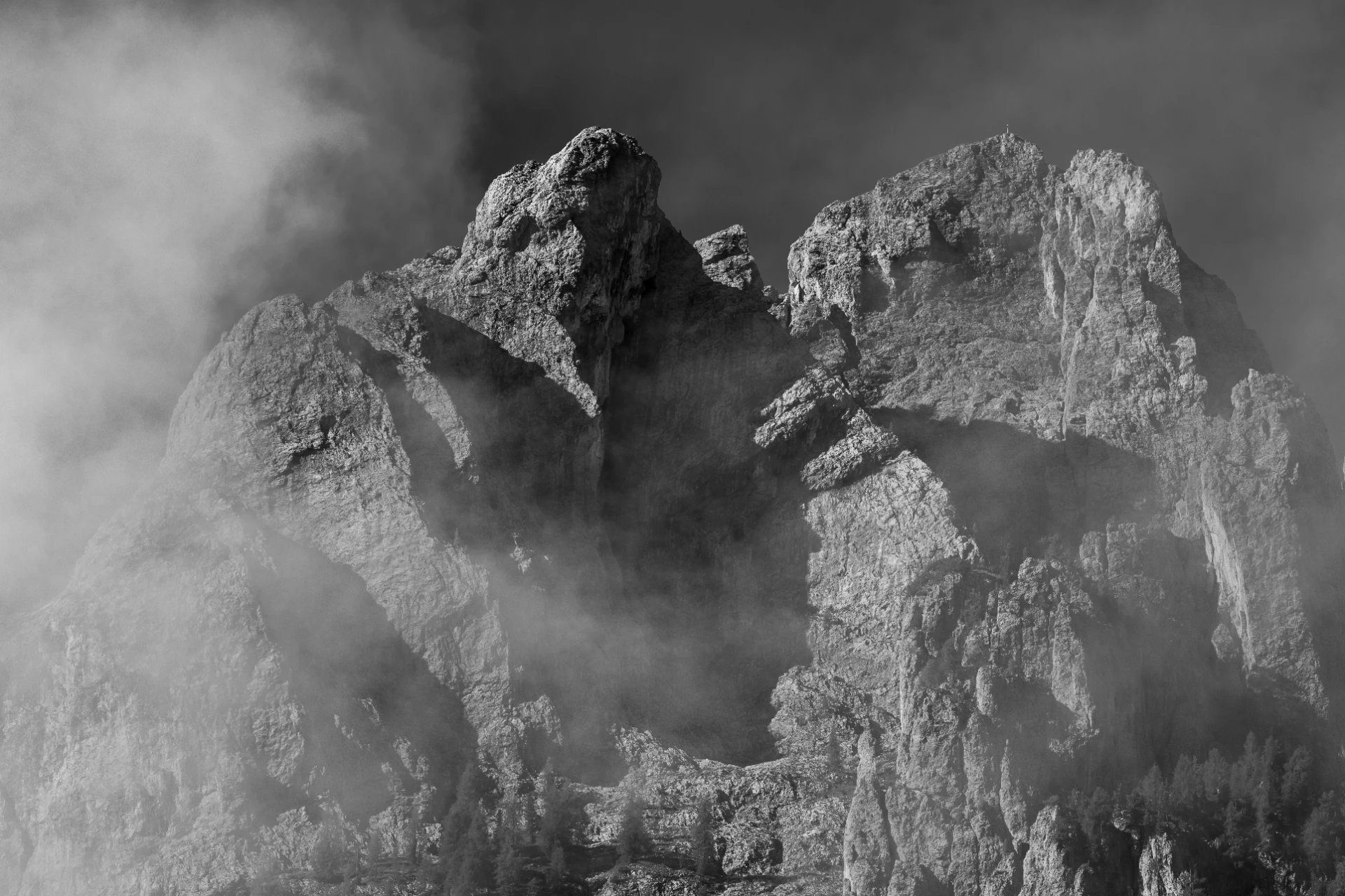 Schroffe Dolomiten-Felsgipfel, umhüllt von sanften Nebelschwaden, im diffusen Licht aufgenommen, minimalistisch und ruhig inszeniert.