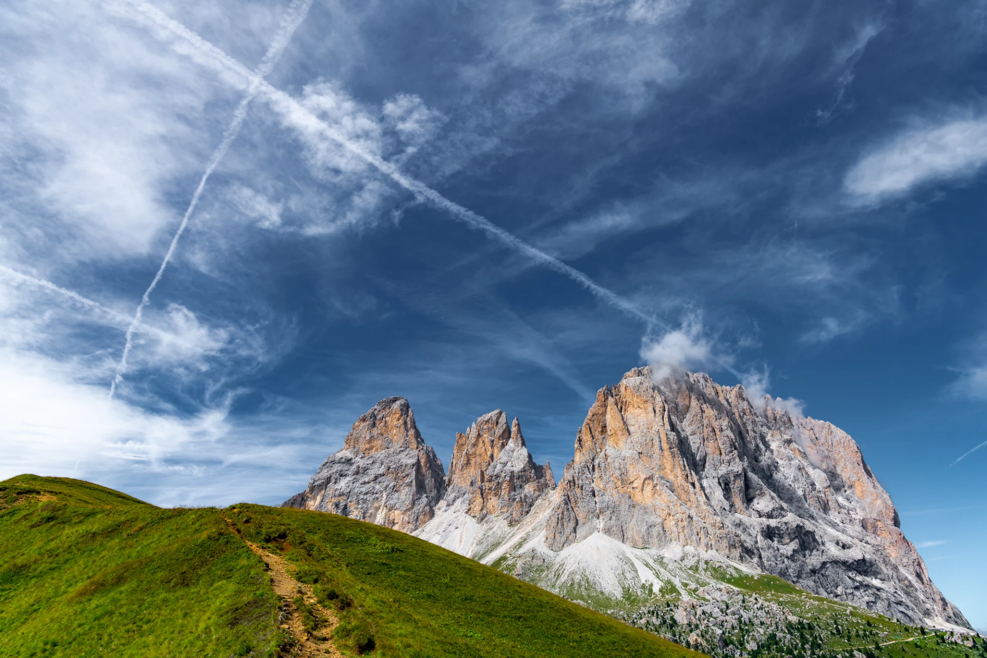 Sanfte Gipfel der Langkofelgruppe mit zarten Wolken, vielfältigen Farben und klaren Konturen in einer erhabenen, natürlichen Berglandschaft