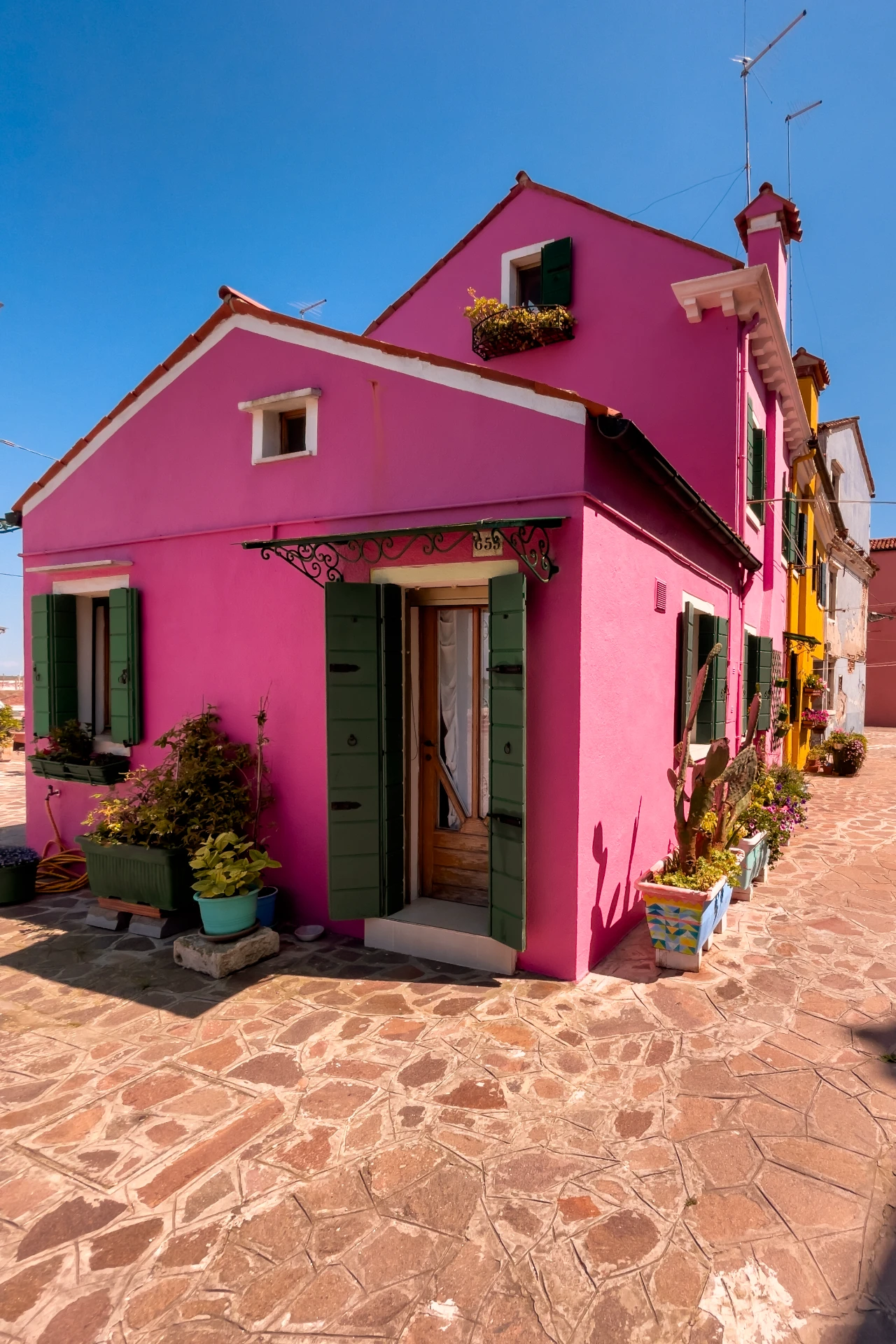 Bunte, geometrisch angeordnete Hausfassade auf Burano mit lebendigen Farben und klaren Linien, urban und fröhlich fotografiert