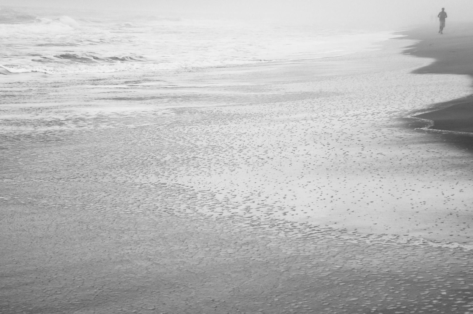 Weitläufiger brasilianischer Sandstrand mit sanftem Morgennebel über dem Meer, weiches Licht und ruhige, mystische Atmosphäre.