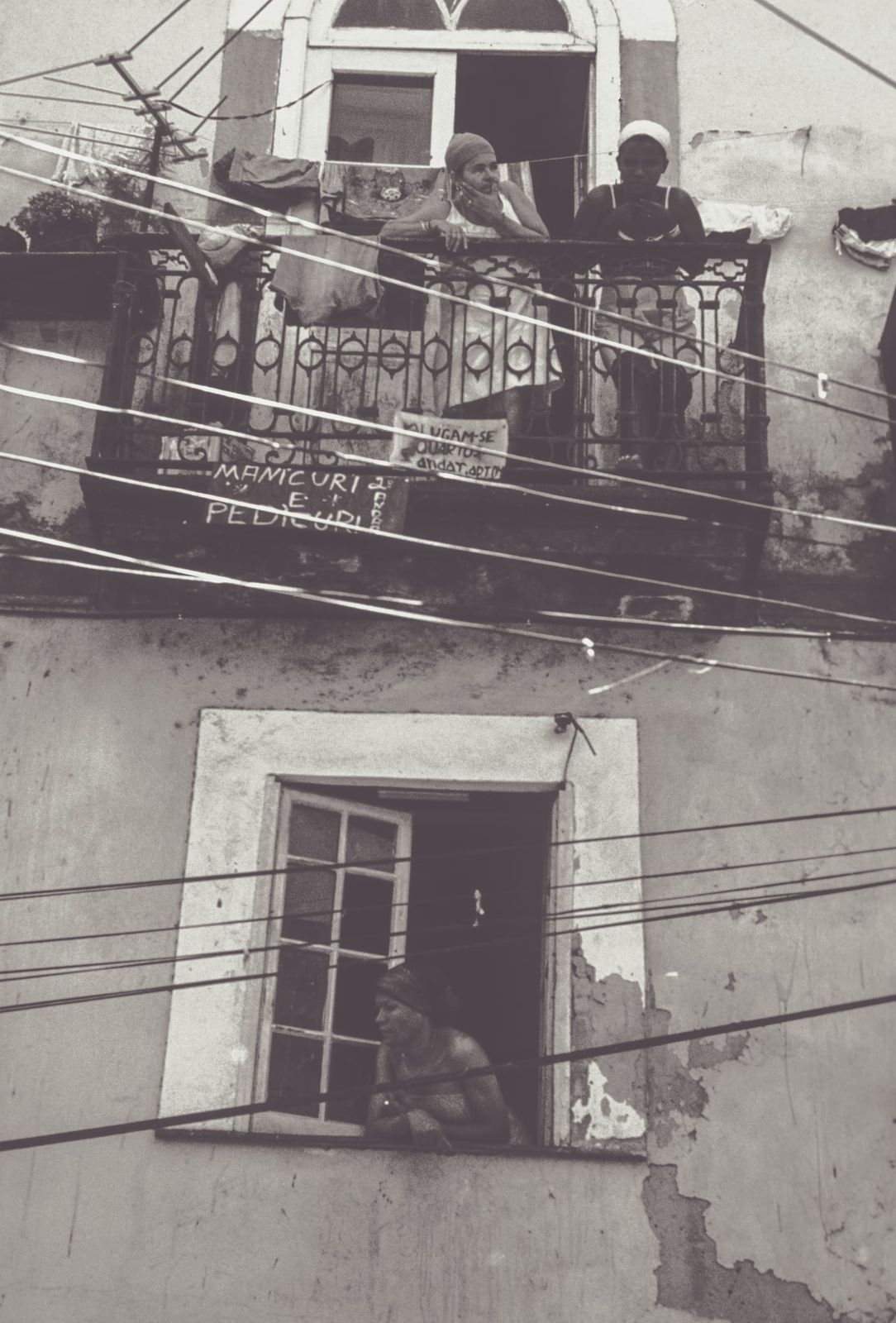 Eine Person lehnt entspannt am geöffneten alten Fenster, Sonnenlicht fällt sanft durch das Glas und beleuchtet den Raum in nostalgischer Atmosphäre.