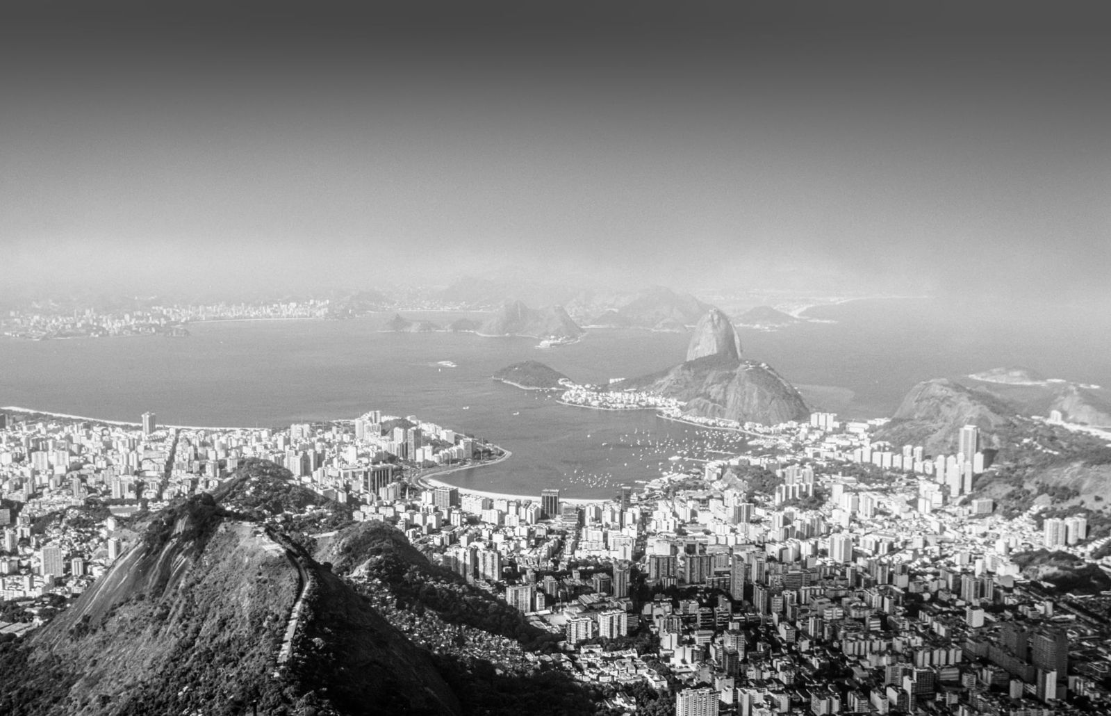 Panorama von Rio de Janeiro mit markanten Silhouetten, silbernen Lichtakzenten und urbaner Skyline in Schwarzweiß.