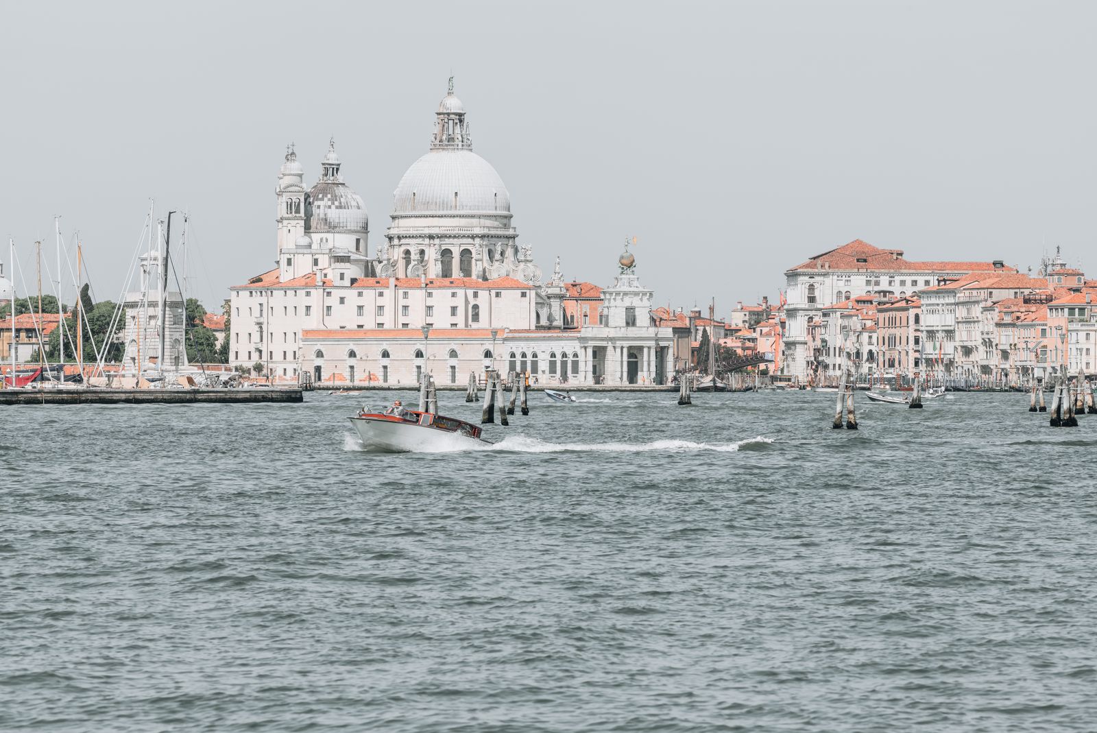 Historische Gebäude von Venedig spiegeln sich im ruhigen Wasser, weiches Licht und sanfte Farben schaffen eine minimalistische, luftige Atmosphäre.