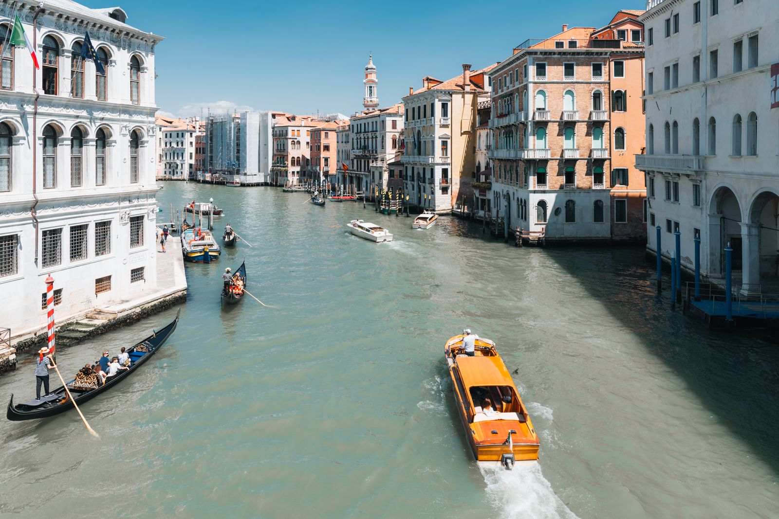 Blick auf den belebten Kanal San Marco in Venedig mit historischen Gebäuden, sanftem Wasser und goldenem Abendlicht im urbanen Ambiente.