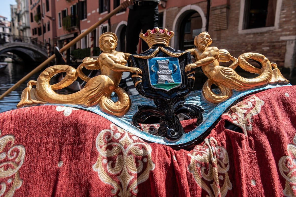 Detailaufnahme einer venezianischen Gondel mit glänzendem Holz, eleganten Kurven und historischen Elementen in vielfältigen Farben.