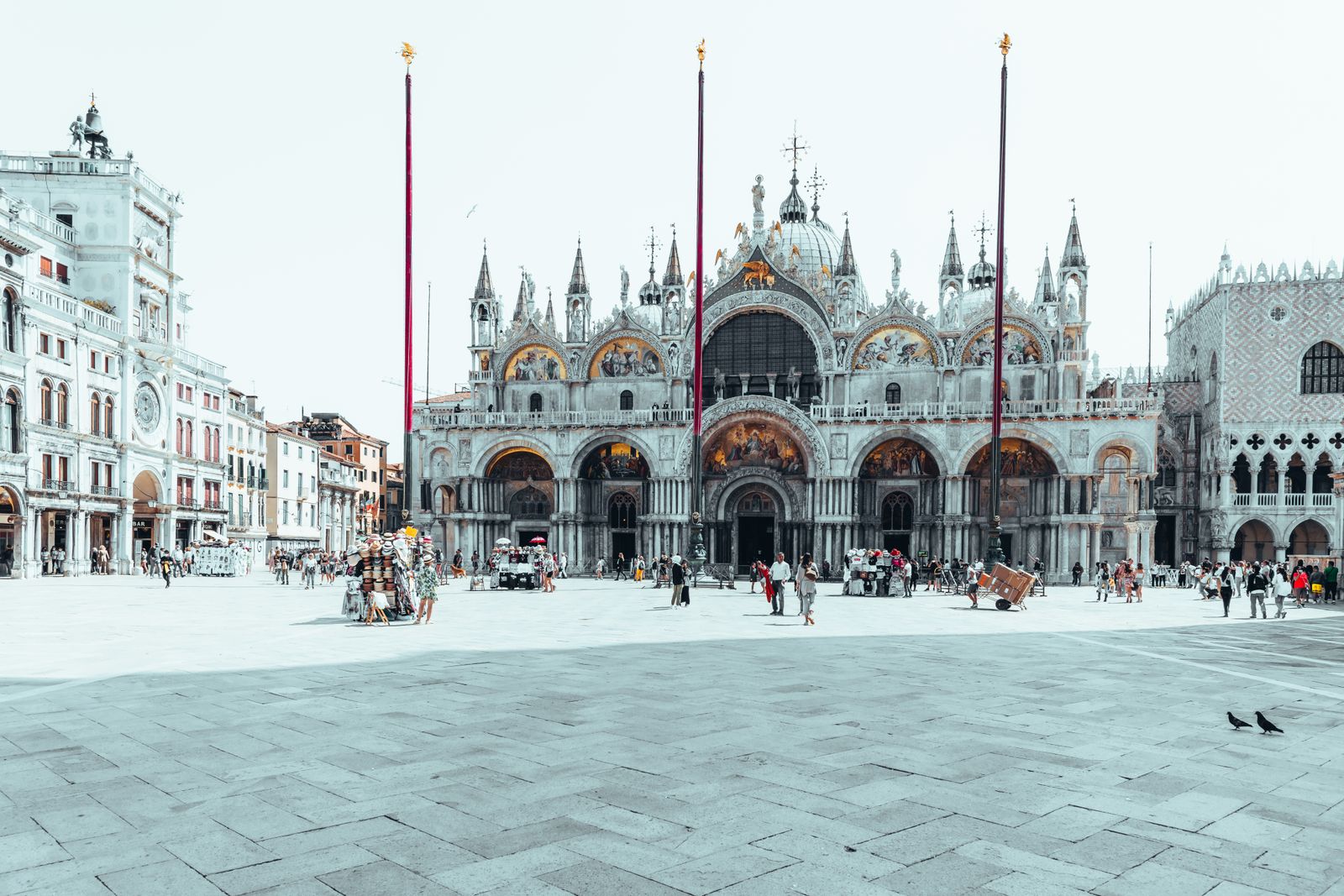 Fotografie des Markusplatzes in Venedig mit Arkaden und filigranen Säulen im goldenen Morgenlicht, urban und historisch inszeniert.
