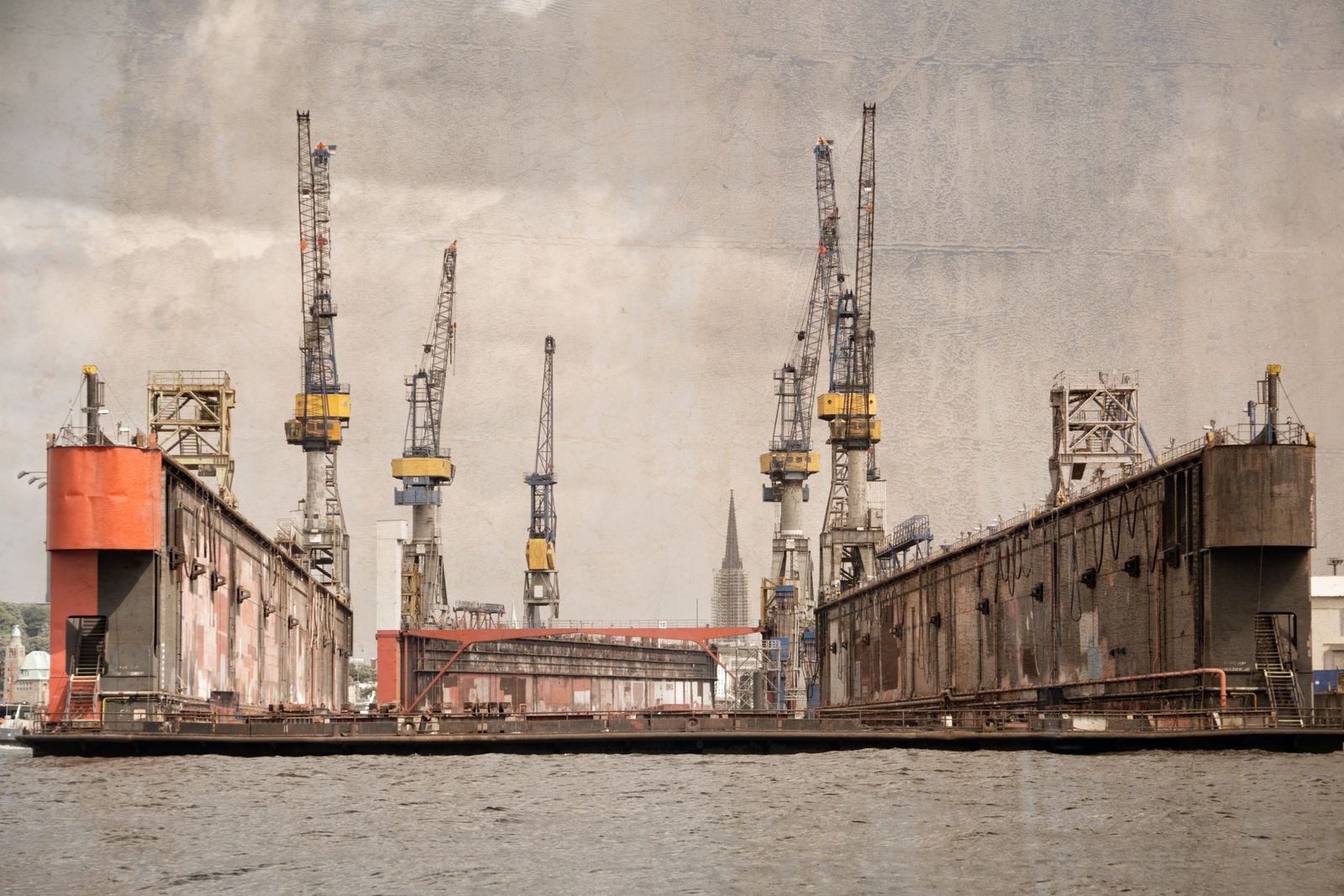 Mehrere große Werftkräne im Hamburger Hafen, eingerahmt von Hafenstrukturen und vielfältigen urbanen Details, dokumentarisch fotografiert.
