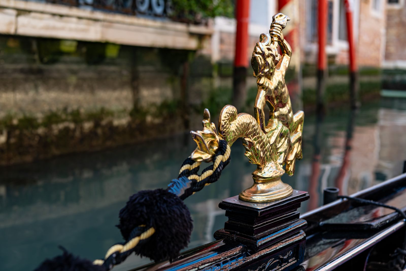 Detailaufnahme einer venezianischen Gondel in San Marco, glänzendes Holz und Lack, Wasserreflexionen, urban und elegant inszeniert