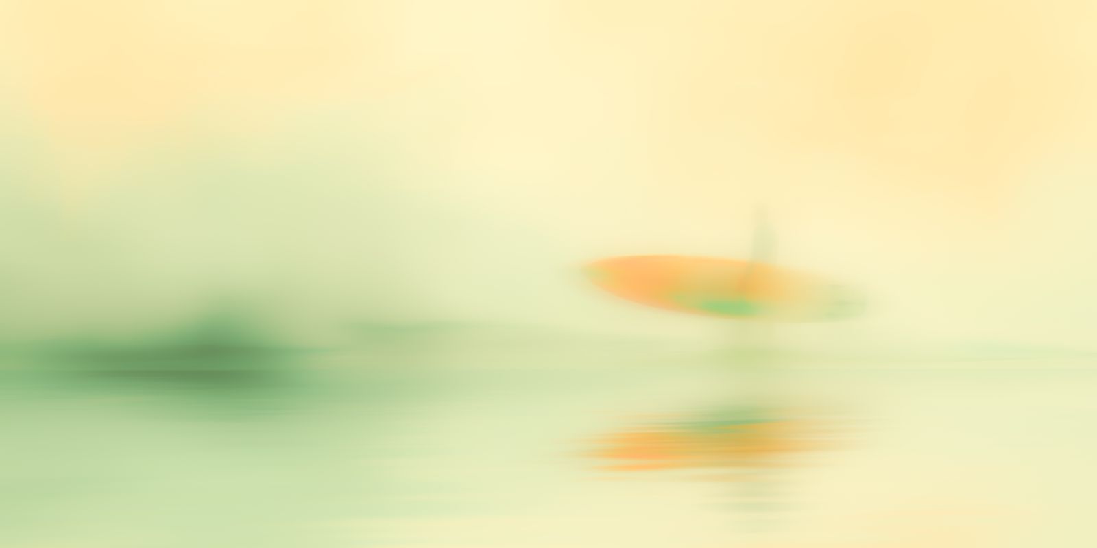 Ein einzelner Surfer steht mit Surfbrett am Strand, umgeben von sanftem Morgennebel und diffusen Farbtönen im Panoramaformat.