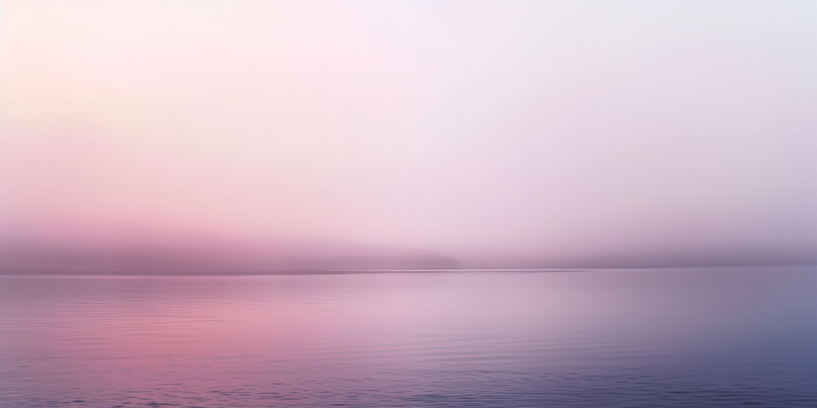 Ein stiller See mit sanftem Morgennebel, zarter Lichtstimmung, spiegelnder Wasseroberfläche und nebligem Ufer im Panoramaformat.