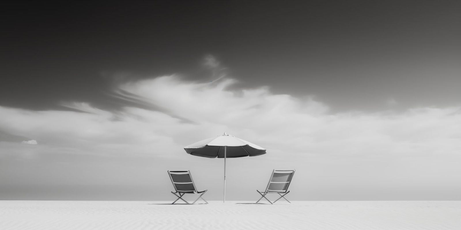 Weitläufiger, menschenleerer Strand mit einem einzelnen Sonnenschirm im Vordergrund, minimalistisch und ruhig inszeniert.