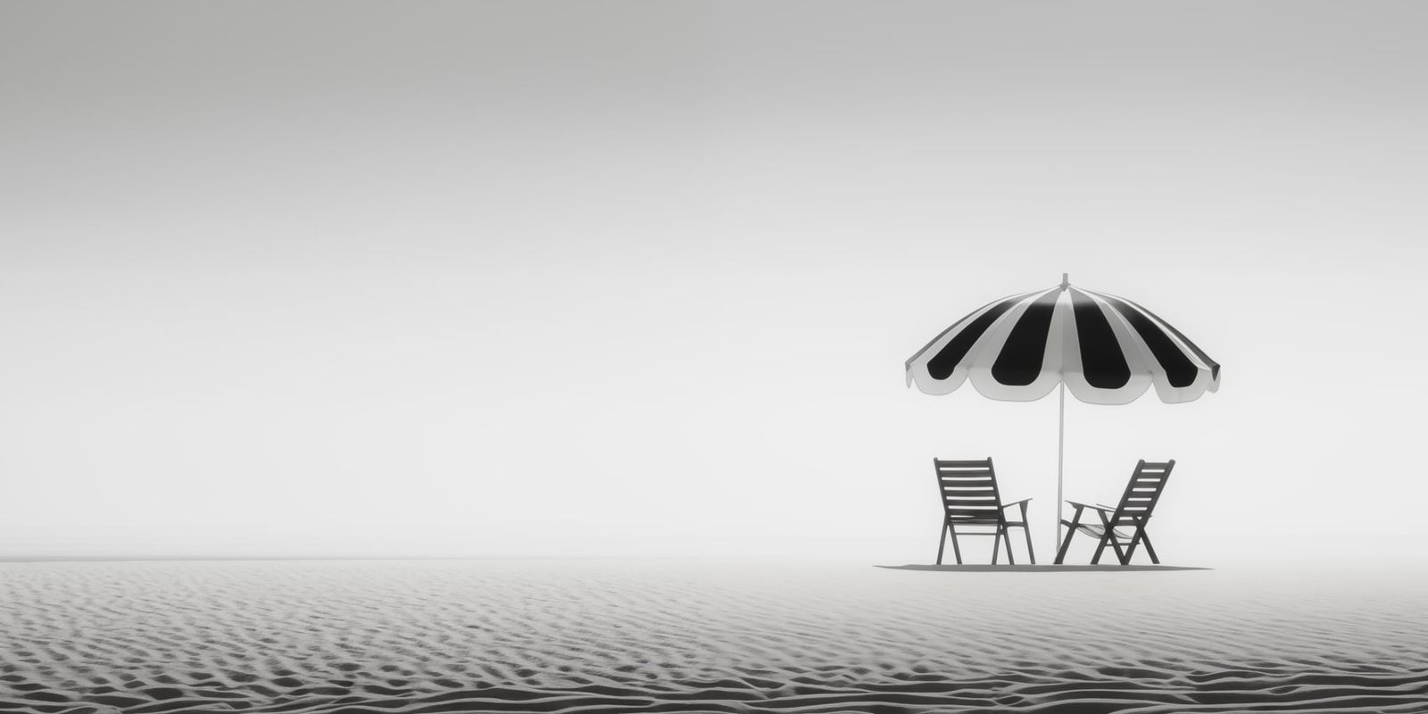 Ein einzelner Sonnenschirm steht auf weiter, fast farbloser Sandfläche an einem minimalistischen Strand unter klarem Himmel.