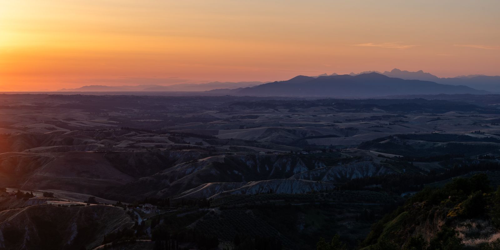 Sanfte, goldene Hügel der Toskana im Panoramaformat, weite Landschaft mit natürlichem Licht und ruhiger, entspannter Atmosphäre.