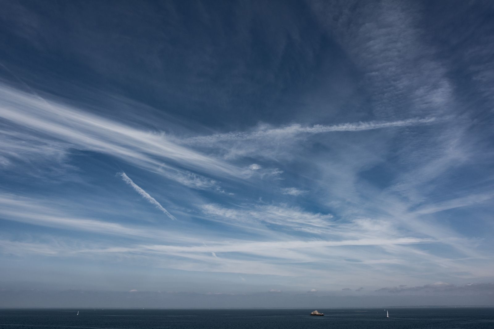 Stiller, spiegelglatter See mit vielfältigen Wolken am Himmel in minimalistischer, ruhiger Naturstimmung