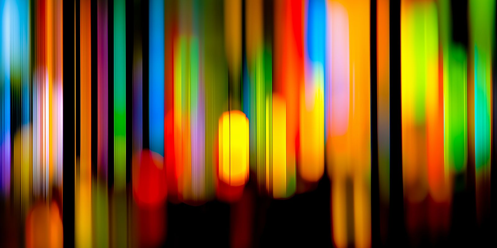Abstraktes Panorama Wandbild mit leuchtenden, bunten Lichtern und dynamischen, farbigen Formen auf dunklem Hintergrund.
