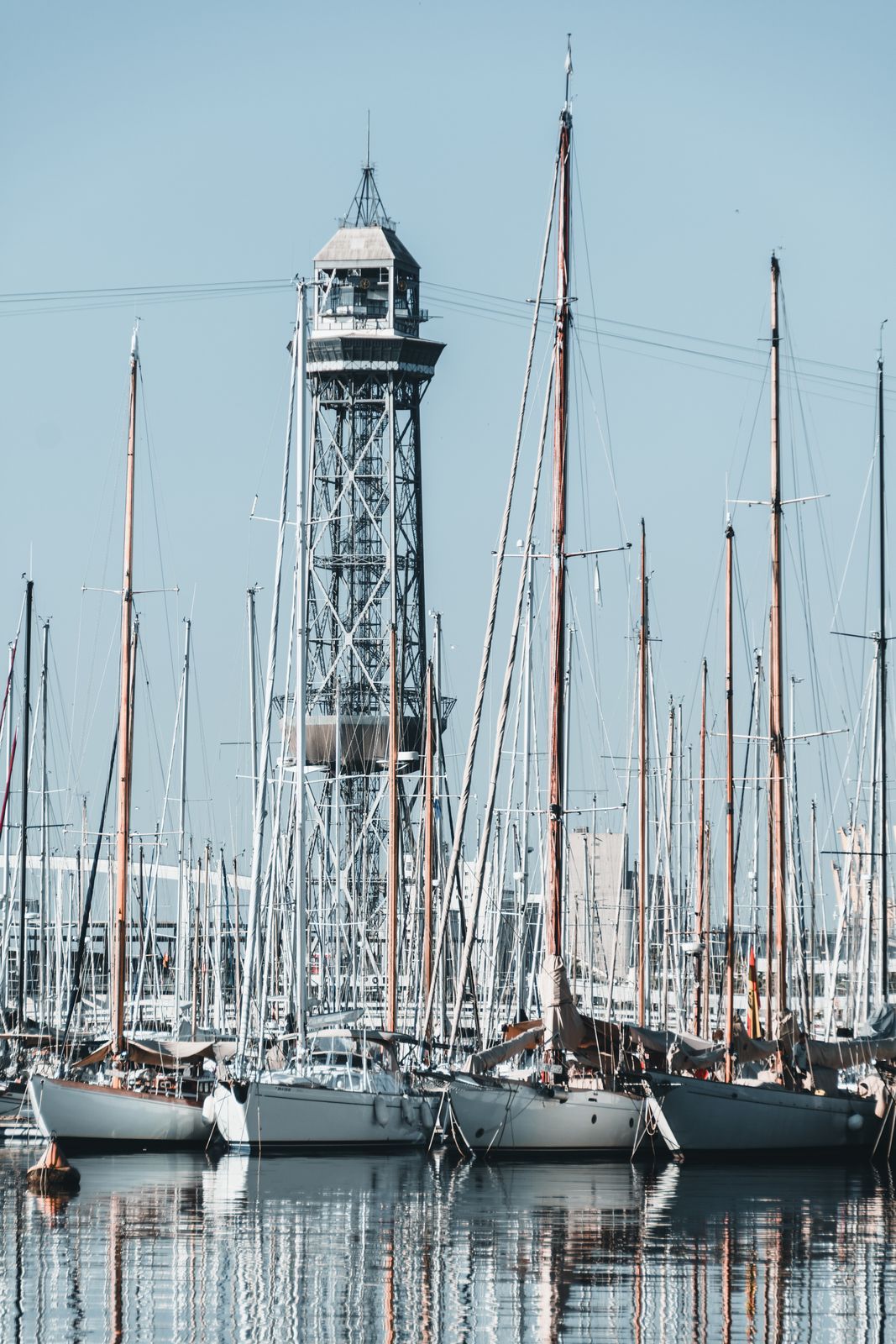 Modernes Panorama des Hafens von Barcelona mit ruhigem Wasser, spiegelnden Booten und vielfältigen Farben im minimalistischen Stil