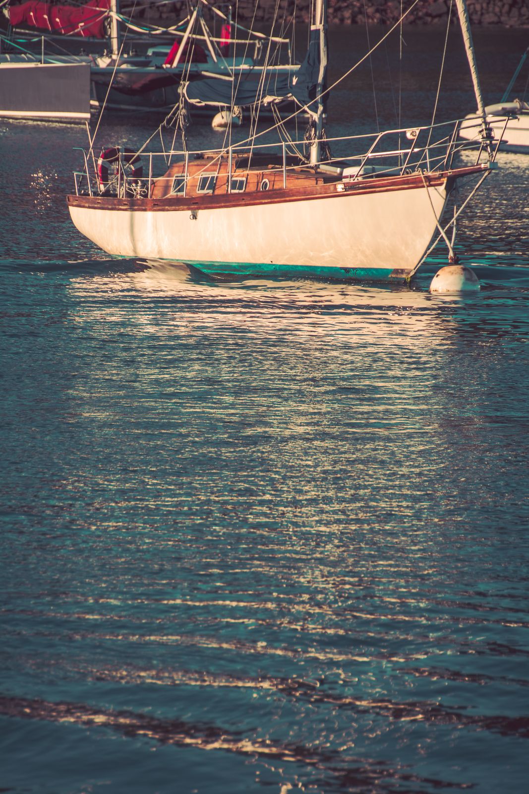 Ein Vintage Segelboot liegt ruhig an einem Hafen, umgeben von sanften Farben und maritimer Atmosphäre im Vintage-Stil.