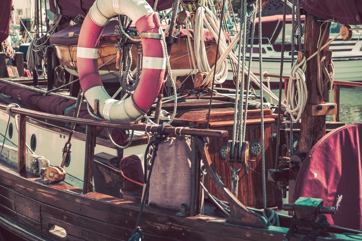 Ein detailreiches Vintage Segelboot liegt ruhig im Wasser vor Stralsund, eingefangen als maritimes, nostalgisches Fotokunst Wandbild.
