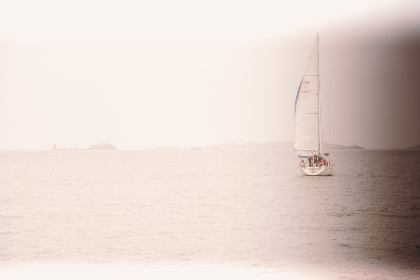Ein einzelnes Segelboot gleitet bei sanftem Licht über ruhiges Wasser, umgeben von zarten Farben und minimalistischer Atmosphäre.