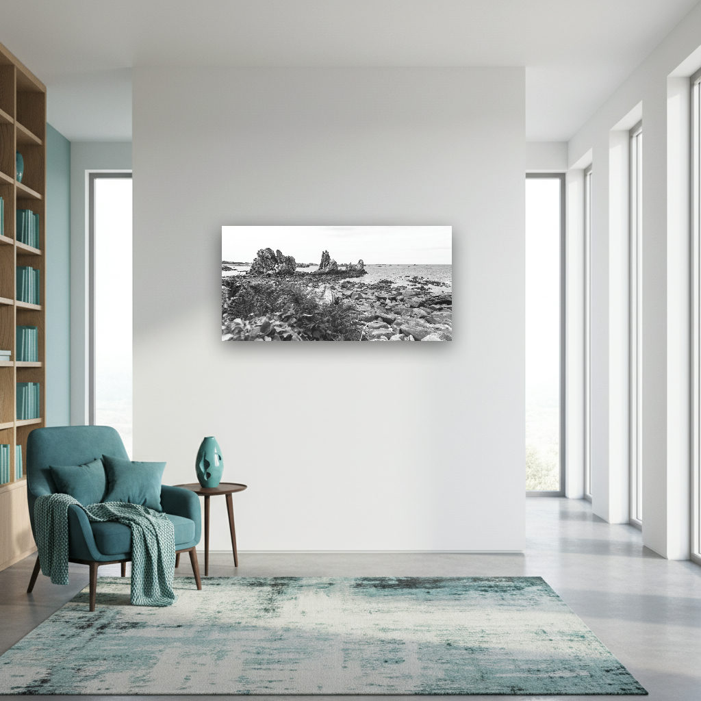Felsige Küste mit rauem Gestein, Wellen und dramatischem Himmel an der Bretagne, minimalistisch und ruhig fotografiert