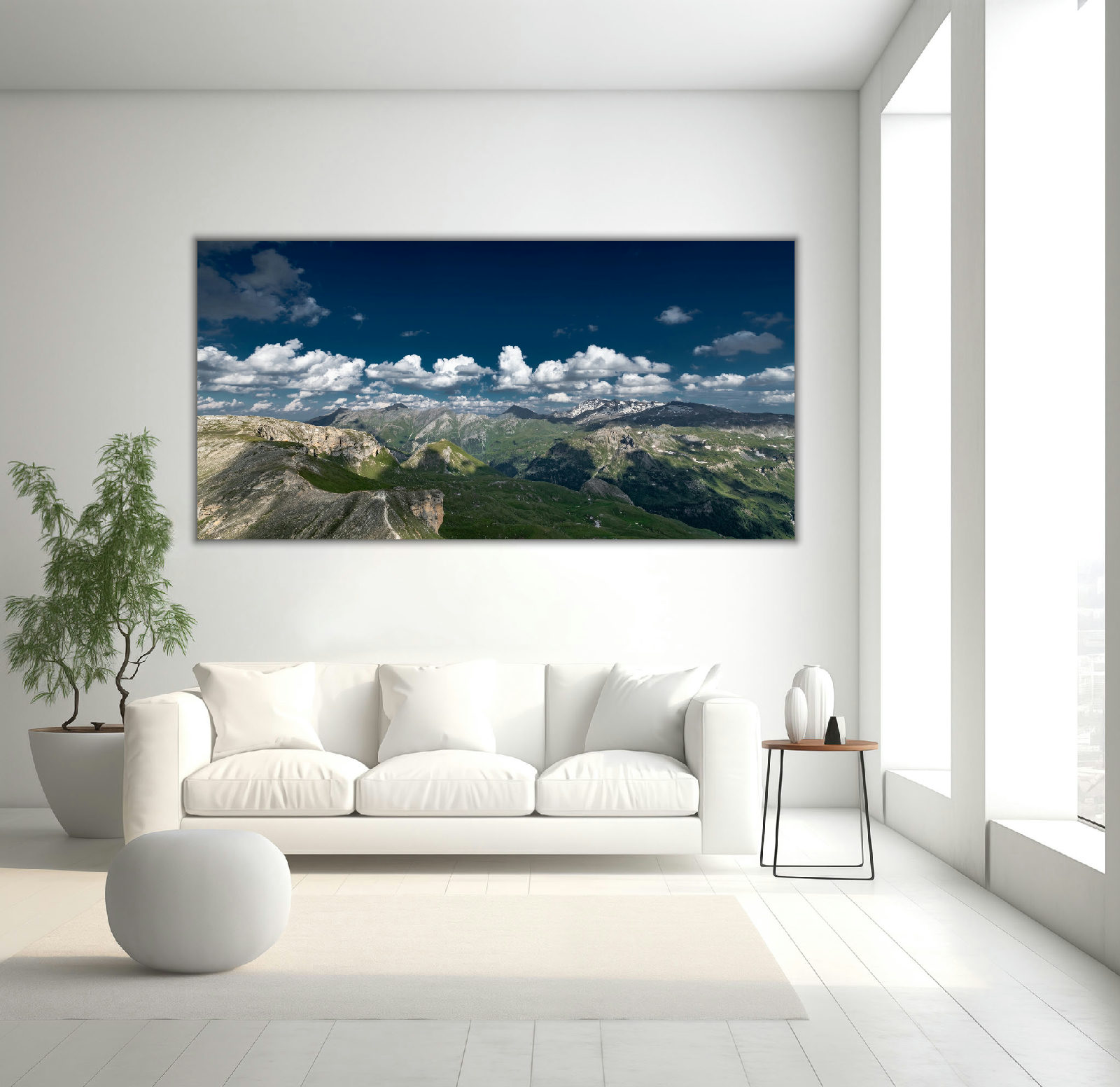 Sanfte Bergrücken und mächtige Alpen-Gipfel unter klarem Himmel, eingefangen als Panorama-Landschaft in vielfältigen Farben.