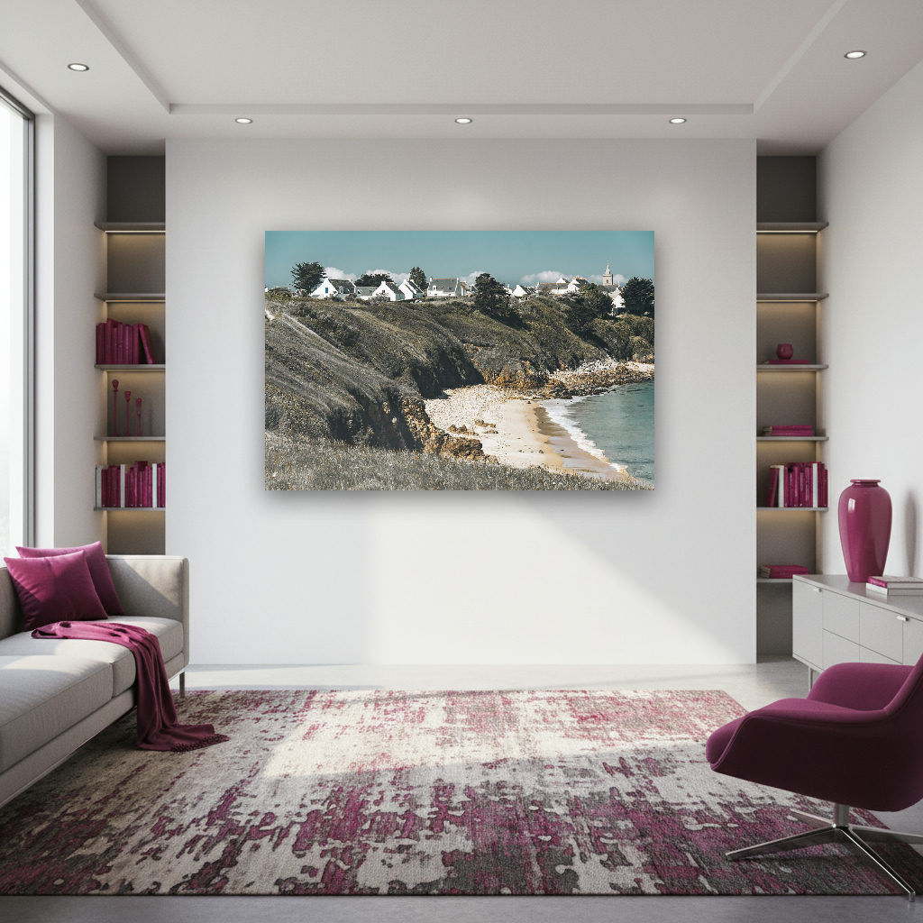 Blick auf ein Dorf mit weißen Häusern an der bretonischen Steilküste über einer Bucht mit Sandstrand.