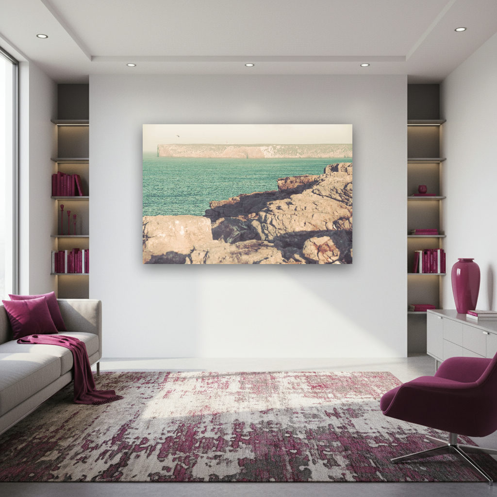 Weite Felsenküste bei Sagres mit rauen Klippen, vielfältigen Naturfarben und sanftem Lichtspiel unter klarem Himmel, minimalistisch inszeniert.