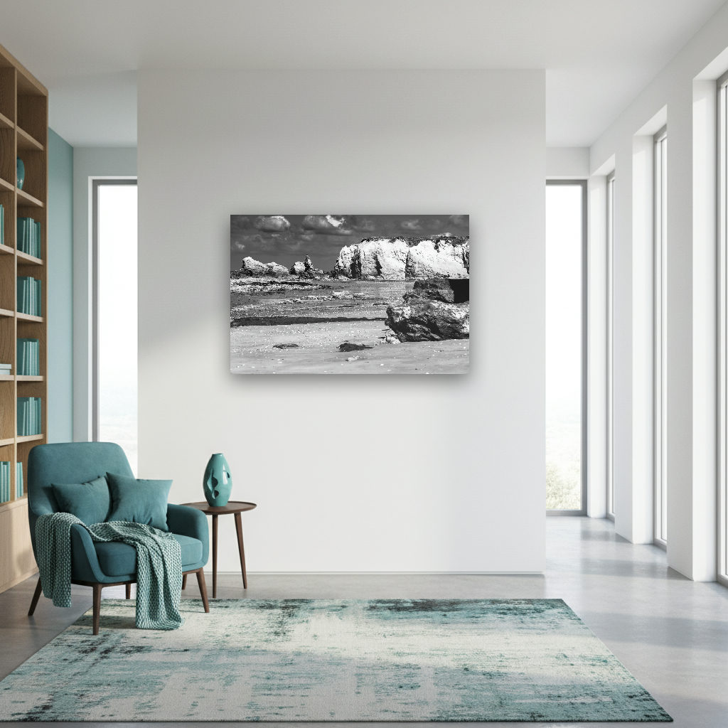 Schwarzweiß-Fotografie einer dramatischen Felsenküste in der Bretagne, Frankreich, mit markanten Felsen und ruhiger See im minimalistischen Stil